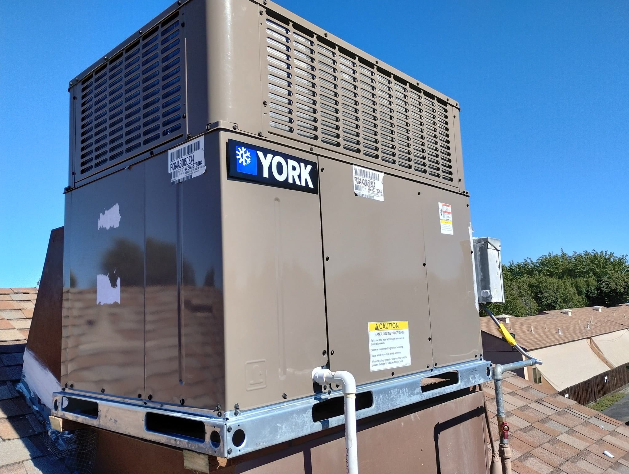 Two York package units installed on a residential rooftop by Cohen Air